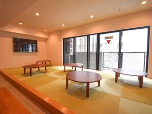 a waiting room with tables and a basketball hoop at HOTEL WINDS ASAKUSA Capsule Inn 浅草 in Tokyo