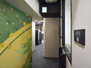 a hallway with a door with a clock on the wall at HOTEL WINDS ASAKUSA Capsule Inn 浅草 in Tokyo +84 photos
