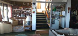 a living room with a staircase and a living room with a refrigerator at Hospedaje La Tuna in Rocha