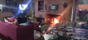 a living room with a brick fireplace and a couch at Hospedaje La Tuna in Rocha