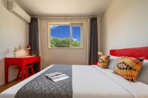 a bedroom with a bed and a red desk and a window at Peking Garden Youth Hostel in Beijing