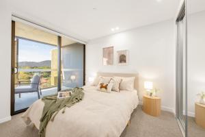 ein Schlafzimmer mit einem großen Bett und einem großen Fenster in der Unterkunft Dickson Stylish 2BR Retreat w Views n Parking in Downer