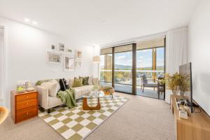 ein Wohnzimmer mit Sofa und Tisch in der Unterkunft Dickson Stylish 2BR Retreat w Views n Parking in Downer