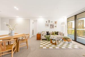 ein Wohnzimmer mit Sofa und Tisch in der Unterkunft Dickson Stylish 2BR Retreat w Views n Parking in Downer