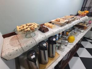 a table with many different types of bread and pastries at Hotel Serra do Mar in Paranaguá