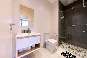 a bathroom with a toilet and a sink and a shower at Sandtongate Heights in Johannesburg