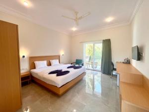 a bedroom with a bed and a large window at Morjim Sunset Hotel in Morjim