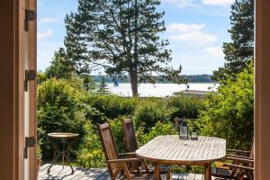 ØlstedBeautiful Summer House With A Magnificent View的享有水景的天井配有桌椅