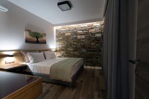 a bedroom with a bed and a stone wall at Aventura Village in Potos +39 photos