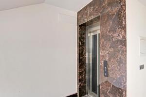 a bathroom with a marble wall with a mirror at Hotel O THE CRIMSON PALACE in New Delhi