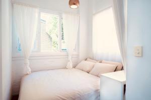 Un dormitorio blanco con una cama y una ventana. en Central stay in Sydney, en Sídney
