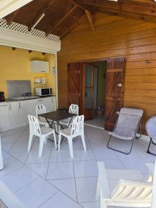 a patio with a table and chairs and a kitchen at bungalow Bô Sicrié in Le Moule