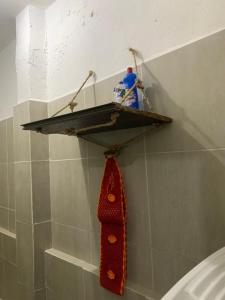 une étagère dans le coin d'une salle de bain avec une cravate rouge dans l'établissement Dream House, à Bayeux 2 autres photos