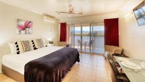 a bedroom with a bed and a balcony at Tweed River Motel in Murwillumbah
