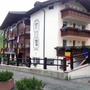 a building with balconies and a clock on it at Hotel Serena in Selva di Val Gardena