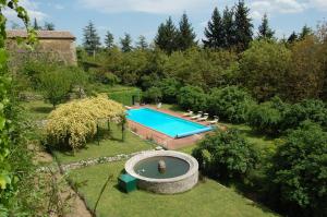 een uitzicht over het zwembad in de tuin bij Badia a Coltibuono Wine Resort & Spa in Gaiole in Chianti