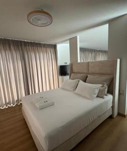 a bedroom with a large white bed with white pillows at Oikos Sani Suites in Sani Beach +20 photos