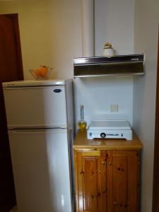 リジアにあるFlokosのキッチン(白い冷蔵庫、コンロ付)