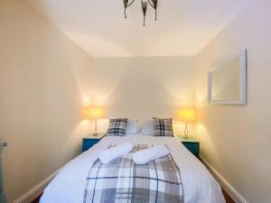 a bedroom with a bed with two pillows at Largs Brisbane Cottage in Largs