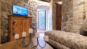 Un dormitorio con una cama en una pared de piedra. en Saxa Suite - Dimore nel Tempo, en Perugia