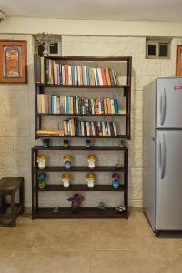 a book shelf filled with books next to a refrigerator at Hotel Papagayo in Playa del Carmen