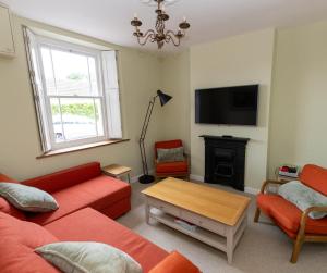 a living room with two red couches and a fireplace at Cozy Cottage, Wrington in Wrington