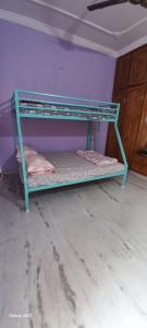 a green bunk bed in a room with a purple wall at Cosy Heights Vizag in Visakhapatnam +20 photos