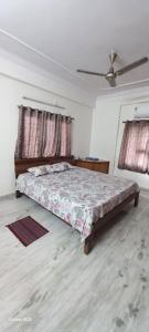a bedroom with a bed and two windows at Cosy Heights Vizag in Visakhapatnam
