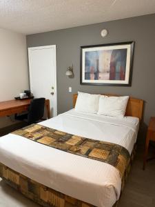 een hotelkamer met een bed en een bureau bij Canadas Best Value Inn Kelowna in Kelowna