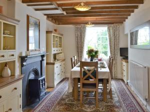 a dining room with a table and a fireplace at Cherry Tree Cottage in Bellerby