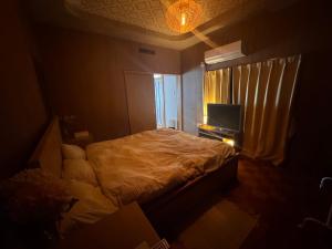 a small bedroom with a bed and a television at SUWAHouse in Gora +2 photos