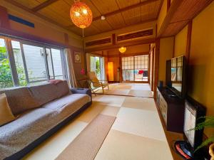 a living room with a couch and a tv at SUWAHouse in Gora