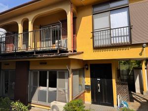 a yellow building with two balconies and a door at SUWAHouse in Gora