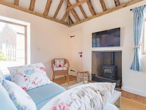 a living room with a couch and a fireplace at Shepherd's Cottage in Pett
