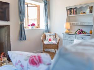 a living room with a chair and a window at Shepherd's Cottage in Pett