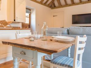 a dining room table with a bottle and chairs at Shepherd's Cottage in Pett +12 photos