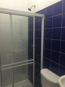 a blue tiled bathroom with a shower and a toilet at Hostel Mamy Dorme in Barranquilla +41 photos