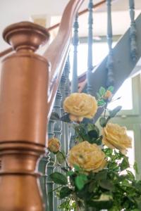 a vase with yellow flowers on a staircase at Vilelmine in Chania