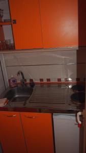 a kitchen counter with a sink and orange cabinets at Marko Apartment in Sutomore