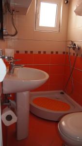 een badkamer met een wastafel, een toilet en een raam bij Marko Apartment in Sutomore