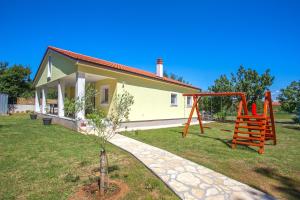 a small house with a playground in front of it at Holiday Home Freeda in Vintijan