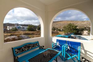 a porch with two arched windows and a bench at Stella's place, Vlichada in Vlychada