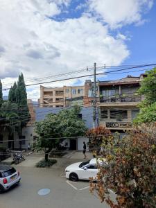 a white car parked in a parking lot next to buildings at Casa Manila Medellin in Medellín