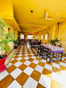 a room with tables and chairs on a checkered floor at Golden Marigold Hotel in Jaisalmer +51 photos