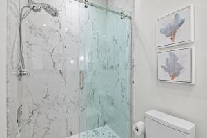 a bathroom with a glass shower with a toilet at Bluehavenon30a-Between Rosemary & Alys Beach -Steps to Beach & Dining-Sleeps 3 in Rosemary Beach