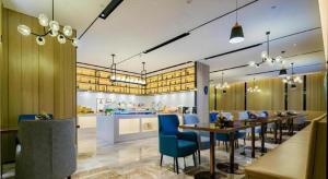 um restaurante com cadeiras e mesas azuis numa sala em Echarm Hotel Xi'an Dayan Tower Datang Lively District em Xian