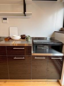 a kitchen with wooden cabinets and a stove at 住之江駐車場付きCozy Family House in Osaka +23 photos