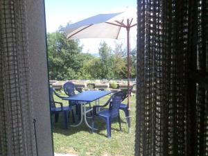 une table et des chaises avec un parasol dans l'herbe dans l'établissement Chambre d'hôtes Littoral 65, à Chez-le-Bart