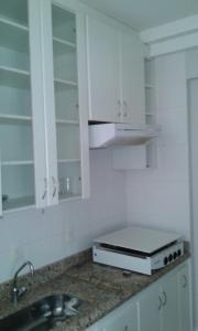 una cocina con armarios blancos y fregadero en #Flats Studio 45 Bueno Oeste, en Goiânia