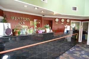 a restaurant with a counter with plants on the wall at Western Inn Lakewood in Lakewood